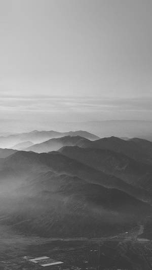 層層山脈在黑白中逐漸融入大氣薄霧的鳥瞰圖。 — 灰色 GIF 壁紙