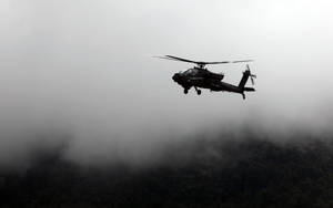 軍用直升機在黎明時分飛越霧濛濛的山脈。 — 直升機 壁紙