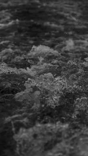 黑白特寫，水流在岩石上翻騰，帶有霧狀水滴。 — 海浪 壁紙