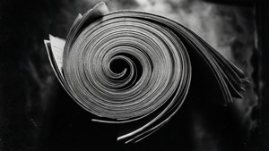 在深色紋理背景上的黑白報紙頁面螺旋。