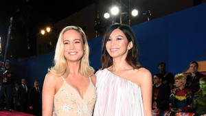 兩位穿著華麗禮服的女性在夜間活動中於紅地毯上微笑。 — 可愛情侶 GIF 壁紙
