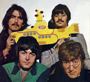 披頭四在攝影棚肖像中拿著一個黃色潛水艇剪紙。 — 水下 壁紙