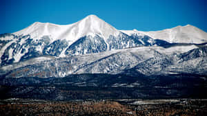 晴朗藍天下白雪覆蓋的山脈，下方是崎嶇的山谷。