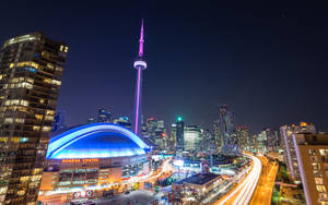 夜晚的多倫多天際線，CN 塔和羅傑斯中心亮起燈光。
