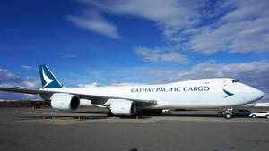 國泰航空貨運波音747在機場停機坪上，藍天白雲