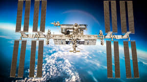 國際太空站漂浮在地球上空，太陽能板展開。 — 外太空 壁紙