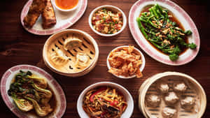 木桌上擺放著包括餃子、春卷和蔬菜在內的中式菜餚盤子。