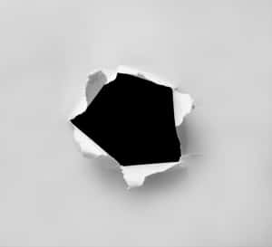 撕開的白紙露出一個黑色的六角形空洞。 — 灰色 GIF 壁紙