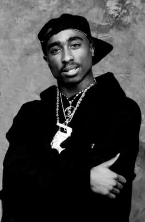 Tupac Shakur 在工作室肖像中戴著帽子和多條項鍊。