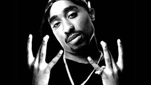 Tupac Shakur在黑白工作室肖像中雙手舉起。