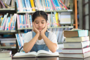 疲倦的女孩在圖書館學習時雙手托頭休息。 — 女孩 壁紙