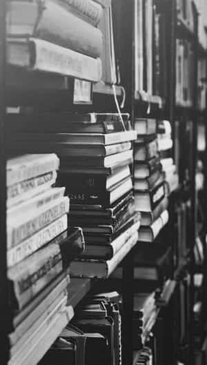 圖書館書架上成排堆疊的書籍，黑白風格 — 書籍 壁紙