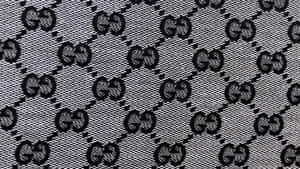 在紋理布料上的黑白Gucci標誌圖案。