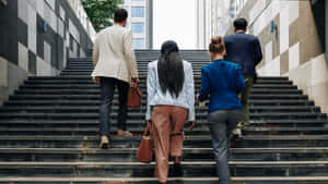 四位穿著商務服裝的專業人士正在攀登城市樓梯。