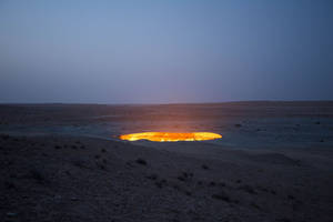 暮色中沙漠裡發光的氣體火山口。 — 暮光 壁紙