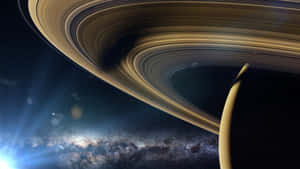 土星環在發光的星雲和星場上空優雅地彎曲。 — 月色夜空 壁紙