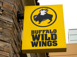 黃色Buffalo Wild Wings餐廳招牌安裝在石頭建築上。
