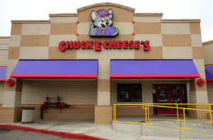 Chuck E Cheese's 餐廳，有卡通老鼠吉祥物和紫色遮陽篷。