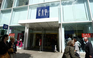 購物者走過一間GAP服裝店，窗戶上可見減價標誌。
