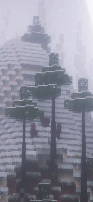 在霧氣瀰漫的Minecraft山景中，積雪的像素樹木。 — iPhone 14 Pro 壁紙