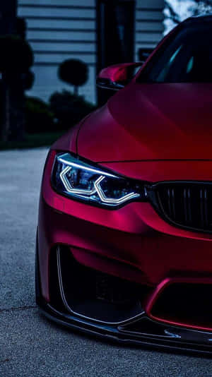 紅色BMW跑車，車頭燈亮起，夜間停泊。