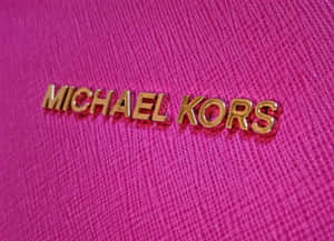 金色Michael Kors標誌在紋理粉紅色布料上。