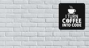 白色磚牆上寫有「I turn coffee into code」的黑色標牌。