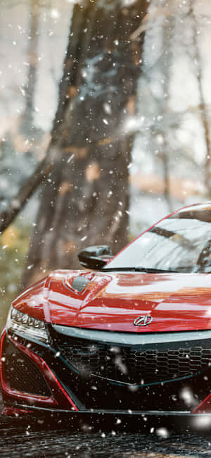 紅色跑車停在雪地森林中，雪花飄落。 — iPhone 16 Pro Max 壁紙