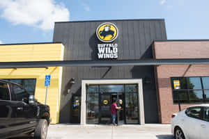 一個人行入 Buffalo Wild Wings 餐廳，外面泊咗車，陽光普照。