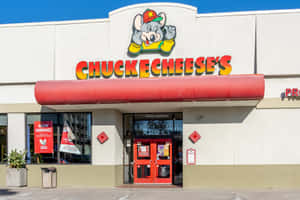 Chuck E Cheese 嘅遊戲機中心同餐廳正面，有紅色簷篷同吉祥物標誌。