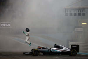 F1車手在煙霧瀰漫的賽道上，在其梅賽德斯賽車旁高興地跳躍。