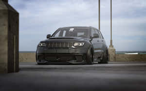 黑色改裝Jeep Grand Cherokee停泊在碼頭上，俯瞰海洋。