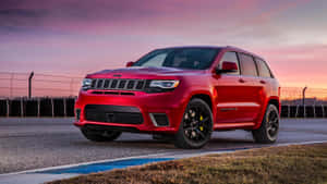 日落時分賽道上的紅色Jeep Grand Cherokee Trackhawk。