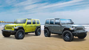 日落時分，兩輛Jeep Wranglers停在靠近海洋碼頭的海灘上。
