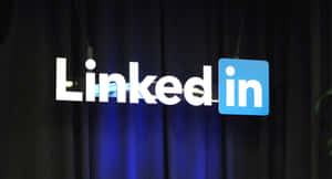 LinkedIn標誌在活動中於深藍色簾幕前亮起。