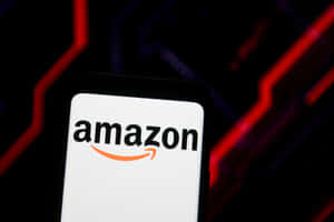 智能手機顯示Amazon標誌，背景有紅色霓虹燈。