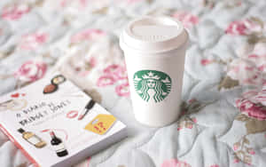 Starbucks咖啡杯同Bridget Jones書喺花卉圖案絎縫床罩上。