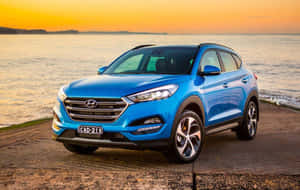 藍色現代 Tucson SUV 停泊在金色日落時分的水邊木製碼頭上。
