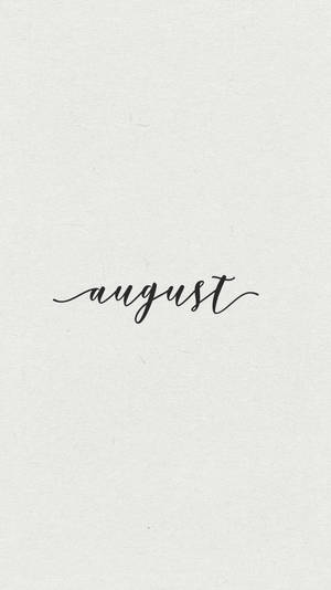 「august」一詞以黑色草書寫在帶紋理的白色紙上。