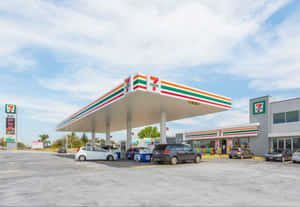 7 eleven加油站，汽車在陽光明媚的日子停泊在條紋簷篷下。