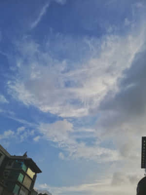 現代建築上方有輕柔白雲的黃昏天空