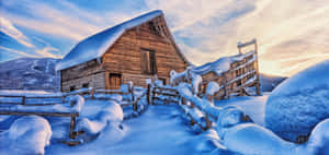 被雪覆蓋的木屋與籬笆，冬季日落景觀