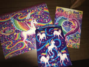 三本獨角獸活動書和一個帶有彩虹翅膀和星星的小袋放在木桌上。