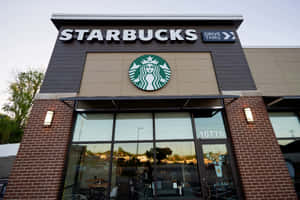 暮色中，Starbucks咖啡店外觀，磚牆和玻璃窗。