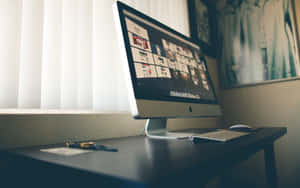 在極簡工作空間中，深色桌子上放著一台現代 iMac，配有百葉窗和牆壁藝術品。