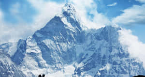 兩個小人影站在藍天下高聳的雪山峰前。
