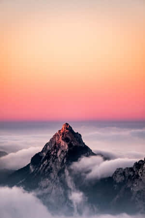 日出時山峰聳立於雲層之上，天空呈現粉紅和橙色。 — POCO Pad 壁紙