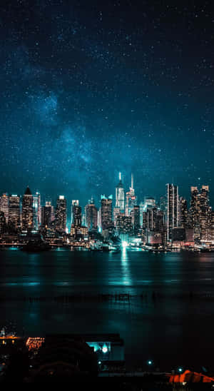 城市天際線夜景，星空與銀河在水面上閃耀 — 夜景城市 壁紙