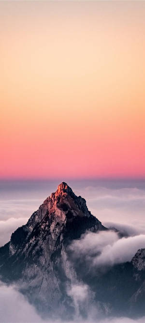 日出時山峰聳立於雲層之上，天空呈現粉紅與橙色。 — Pixel 9 Pro Fold 壁紙
