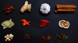 各種完整的香料和香草整齊地排列在深色背景上。 — Studio Display 壁紙